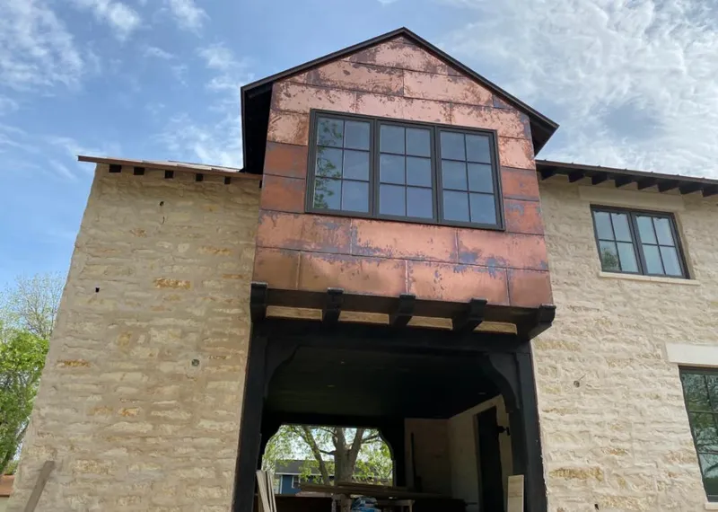 Copper metal panel facade on a stone building for Skylight Installation in Alden